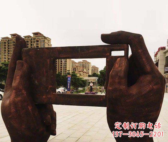 广场拿着手机照相的手景观铜雕